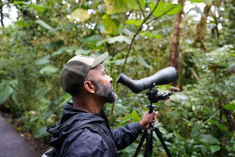 Expert local birding guide pointing out bird species to a small group in Monteverde cloud forest Costa Rica